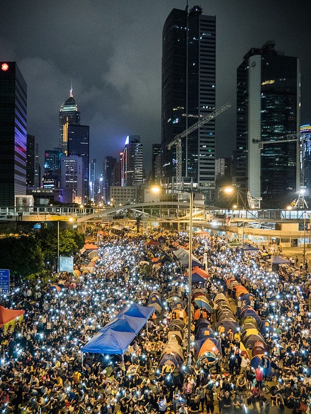 Large nighttime crowd of Hong Kong protestors holding up mobile phone lights during the Umbrella Revolution.