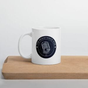 White ceramic mug with The Resistance Hub logo, displayed on wooden block