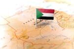 Small Sudanese flag pinned on a map at Khartoum, highlighting Sudan’s location in Northeast Africa.
