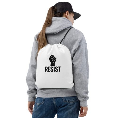 Woman wearing white RESIST drawstring bag with raised fist design